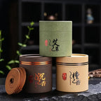 Trois boîtes d'encens en bobine et leurs spirales posées sur une pierre noire