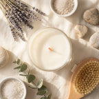 Bougie naturelle Joie en verre avec fleurs séchées et éléments spa sur surface minimaliste crème