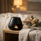 Brûle parfum Scentchips Bulb noir avec bougie allumée sur table de nuit minimaliste