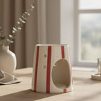 Un Diffuseur de Cire Rayé Rouge Scentchips sur une table en bois vu de trois quarts