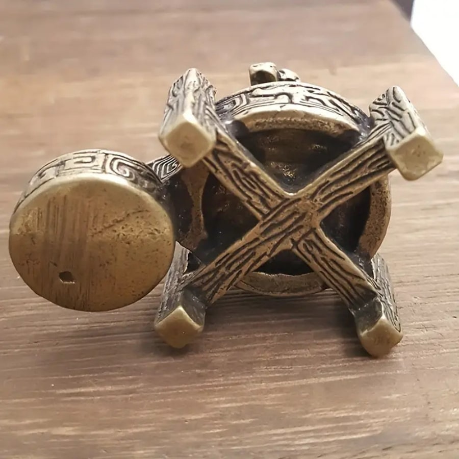 Un brûleur d'encens en cascade en bronze vu de dessous, montrant sa structure et sa base.