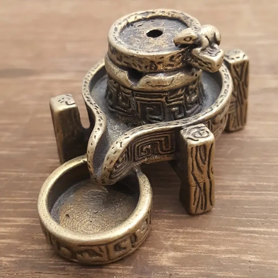 Un brûleur d'encens en cascade en bronze vu de près, montrant les détails sculptés.