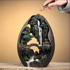 Un brûleur d'encens à refoulement cascade montagne avec une main posant un encens