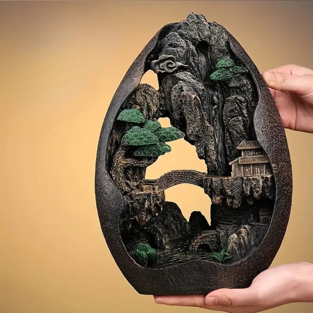 deux mains tenant un brûleur d'encens à refoulement cascade montagne