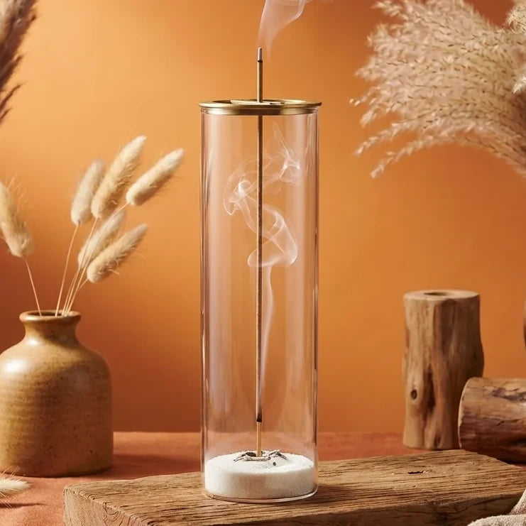 Brûleur encens verre cylindrique transparent design zen avec fumée et sable blanc