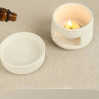 Un brûleur d'huiles essentielles avec un flacon d'huile essentielle et une bougie chauffe plat