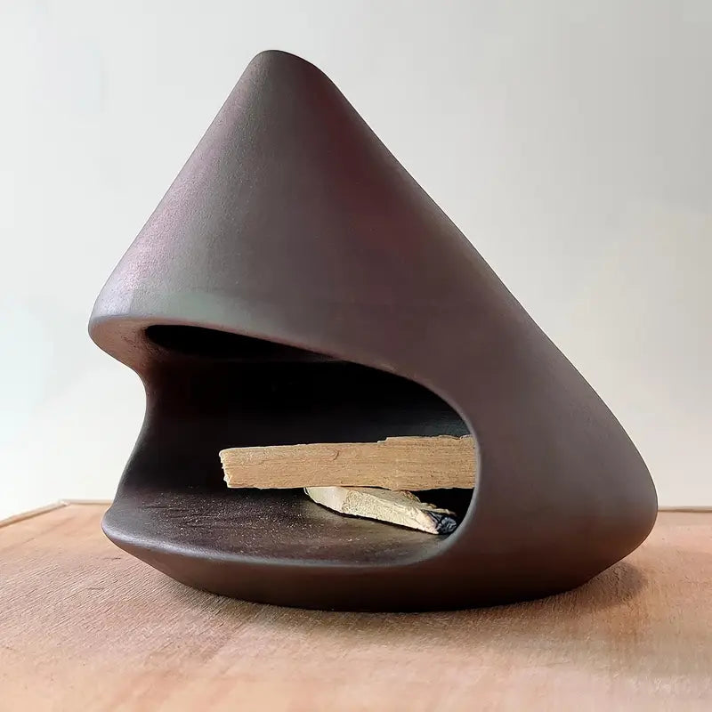 Brûleur d'encens en céramique avec bâtons de Palo Santo posés à l'intérieur