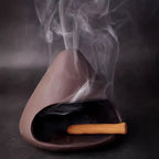 Brûleur en céramique avec encens allumé diffusant de la fumée