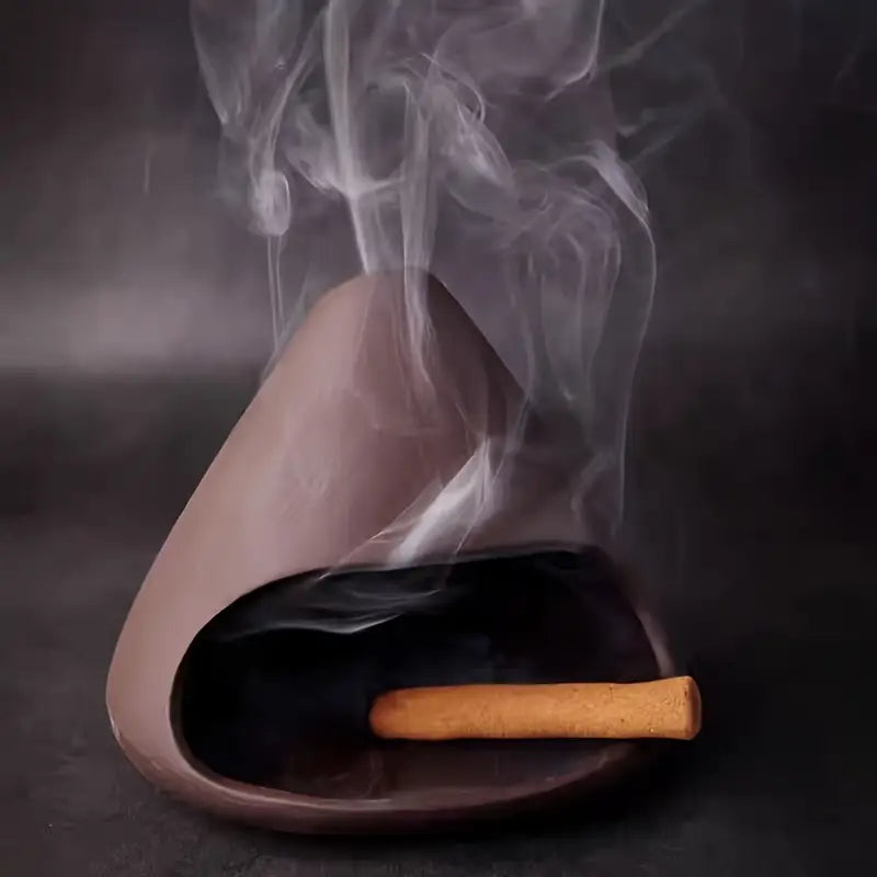 Brûleur en céramique avec encens allumé diffusant de la fumée