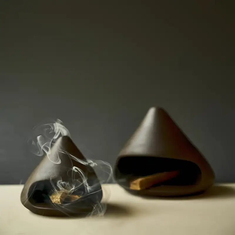 Deux brûleurs artisanaux côte à côte avec fumée d'encens