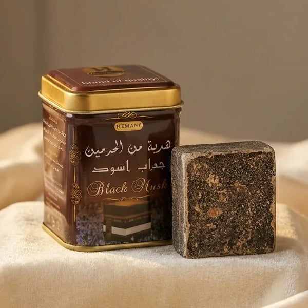 Carré d'Ambre Solide Musc Noir 30g Hemani sur tissu luxueux avec éclairage studio doré