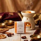 Packshot d'un paquet de quatre carrés fondants Drake à la senteur Oriental devant un brûle parfum allumé