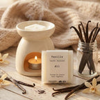 Un paquet de quatre carrés fondants Drake à la senteur Vanille devant des gousse de vanilles et un brûle parfum sur une table en bois