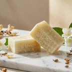 Carrés d'Ambre Jasmin ByBazz 50g sur marbre avec fleurs de jasmin