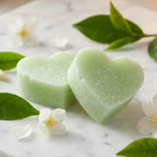 Carrés fondants thé vert cœur ByBazz avec feuilles de thé frais sur marbre blanc