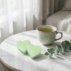 Carrés fondants thé vert cœur ByBazz 50g sur marbre blanc avec tasse de thé