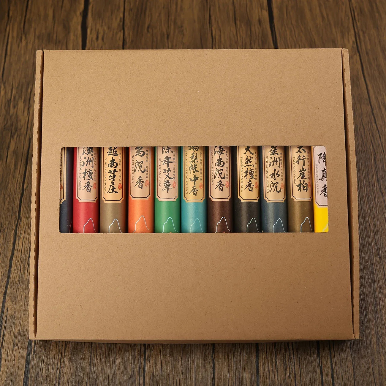 Un coffret de 440 Bâtonnets d’Encens Naturels de11 Parfums, fermé, et posé sur une table en bois