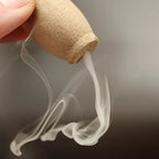 Un cône d'encens à reflux en train de fumer vers le bas