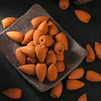 Des cônes d'encens à reflux disposés dans une coupelle en pierre noire