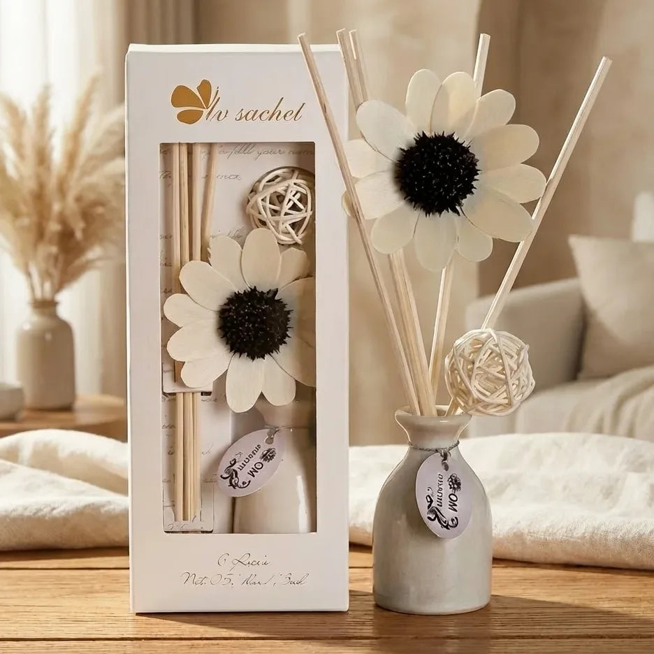 Diffuseur de parfum à bâtonnets blanc décoratif avec fleur marguerite sur surface bois
