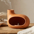 Diffuseur encens maison orange en céramique artisanale sur surface bois, décoration zen minimaliste