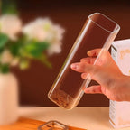 Une main portant un diffuseur d'encens en verre