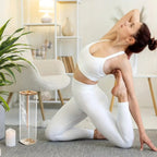 Une femme faisant du yoga à côté d'un diffuseur d'encens