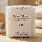 Fondants parfumés musc blanc cire végétale colza dans boîte blanche avec bougie allumée