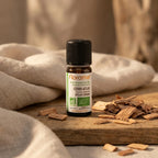 Flacon d'huile essentielle bio Cèdre Atlas Florame 10ml sur surface bois avec copeaux de cèdre