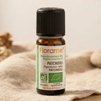 Flacon d'huile essentielle bio patchouli 10 ml Florame sur fond minimaliste avec textures naturelles