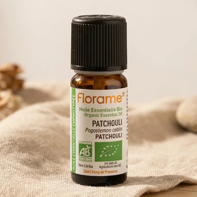 Flacon d'huile essentielle bio patchouli 10 ml Florame sur fond minimaliste avec textures naturelles