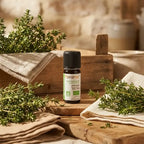 Flacon d'huile essentielle bio Thym Fort Florame 5ml entouré de brins de thym frais et éléments provençaux