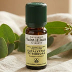 Flacon d'huile essentielle d'eucalyptus citronné bio 10ml avec feuilles fraîches sur tissu lin
