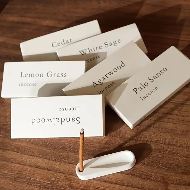 Les boites des 5 senteurs de Mini bâtons d'encens naturel (10 unités) posées à côté d'un mini porte-encens