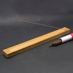 un port encens en bois avec un bâton d'encens fumant