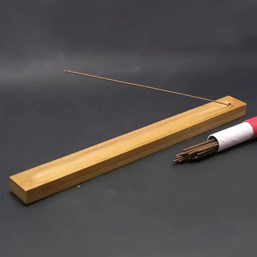 un port encens en bois avec un bâton d'encens fumant