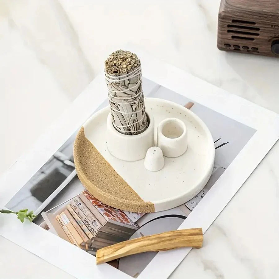 Un porte encens 3 en 1 avec une sauge un bâton de palo santo et un encens posé sur un magazine