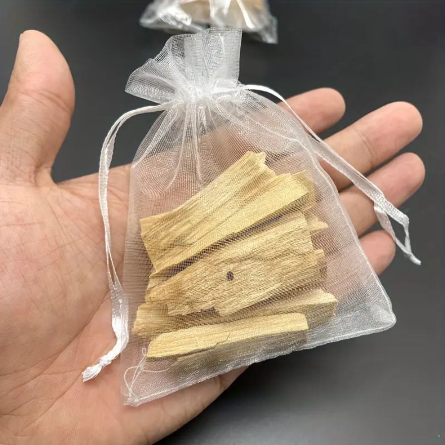 un  sachet de 22 g de Bâtonnets de Palo Santo tenu en main