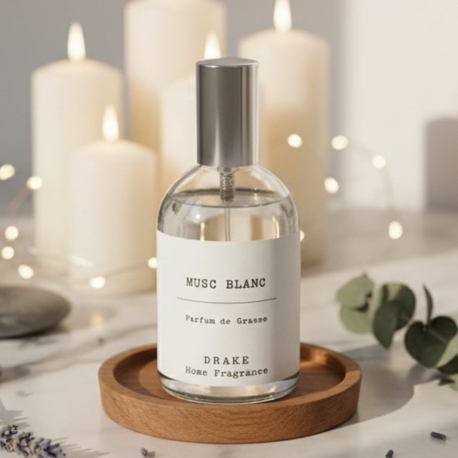 Un spray d'ambiance au musc blanc de la marque Drake posé sur un support en bois avec des bougies