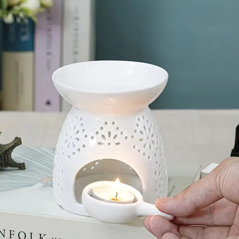 Une main posant un support pour bougie chauffe plat dans un brûloir